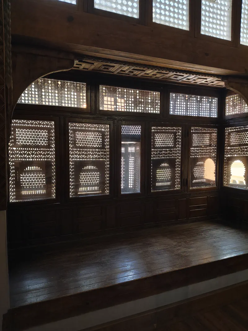 Carved wooden screens filtering daylight inside a Coptic Cairo heritage interior