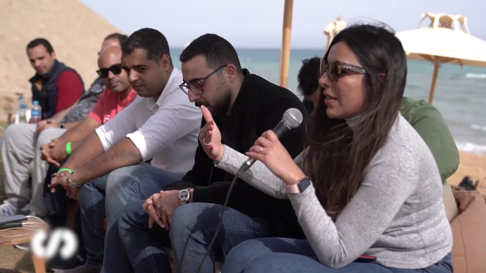A participant speaking into a microphone during a group discussion.